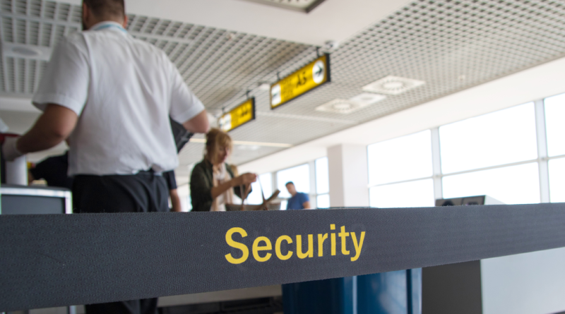ravelers at TSA checkpoint showing REAL ID at airport