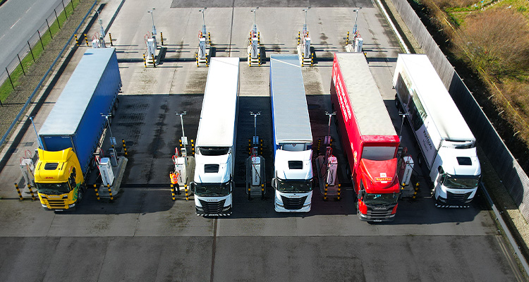 A line of trucks taking on fuel at the pumps