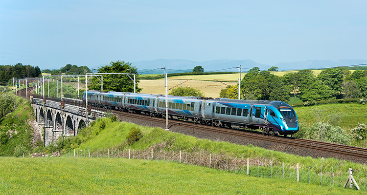 a TransPennine Express train, traversing a viaduct in a rural setting.