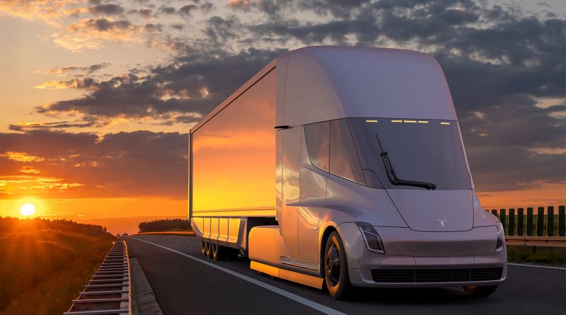 Tesla Semi trucks at a charging station with Uber Freight branding, symbolizing a logistics partnership