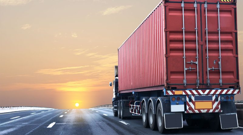 A parked flatbed truck on an empty highway under cloudy skies, symbolizing a slowdown in the freight industry