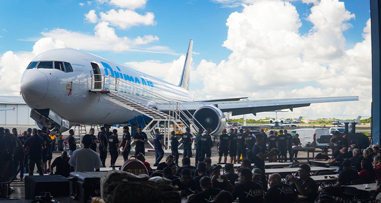 Boeing 767-300F aircraft on the tarmac at an airport, surrounded by a crowd of people